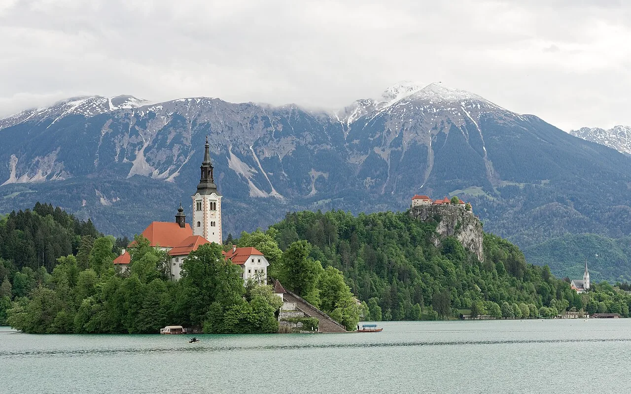 Bled Island with its church, the castle on the cliff behind and the Julian Alps beyond