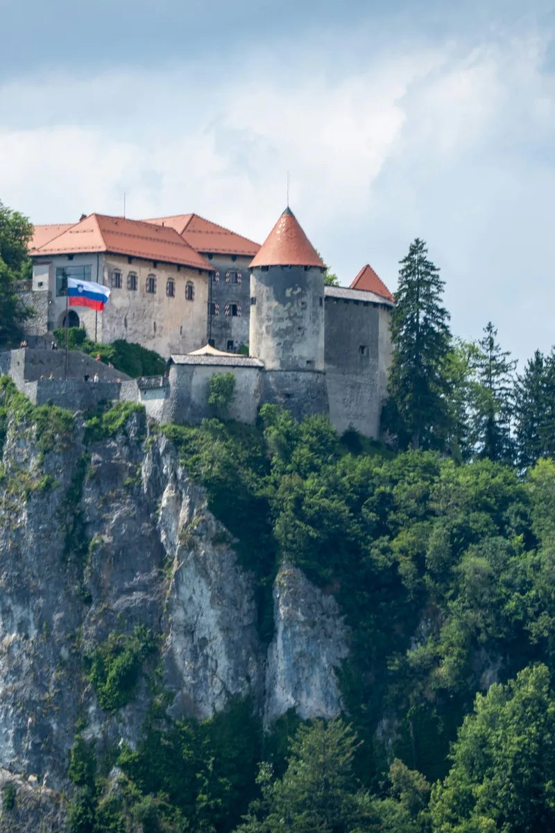 Il Castello di Bled sulla sua scogliera sopra le acque smeraldo del Lago di Bled, con la chiesa sull’isola e le Alpi Giulie sullo sfondo